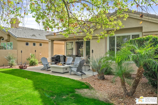 rear view of house featuring a fire pit, a patio area, and a lawn