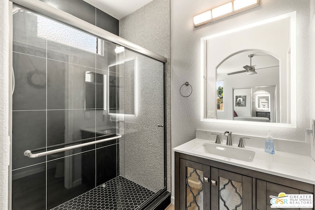 bathroom with ceiling fan, vanity, and walk in shower