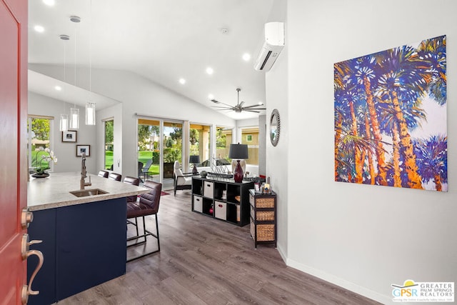 interior space with lofted ceiling, dark wood-type flooring, a kitchen breakfast bar, an AC wall unit, and ceiling fan