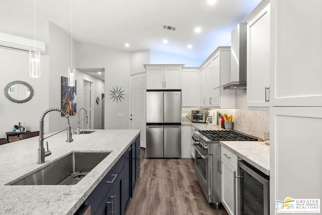 kitchen with lofted ceiling, white cabinets, sink, hanging light fixtures, and stainless steel appliances