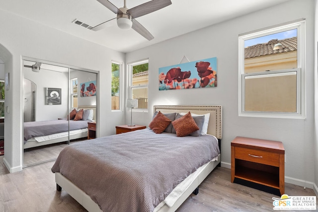 bedroom featuring hardwood / wood-style flooring, ceiling fan, and a closet