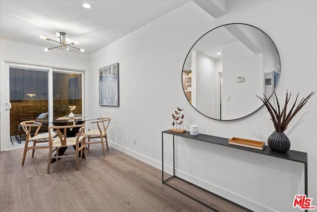 dining room with hardwood / wood-style floors and an inviting chandelier