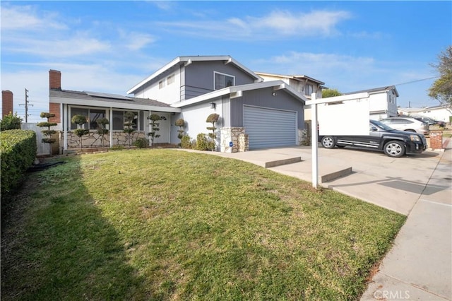 view of front of property featuring solar panels, a garage, and a front lawn