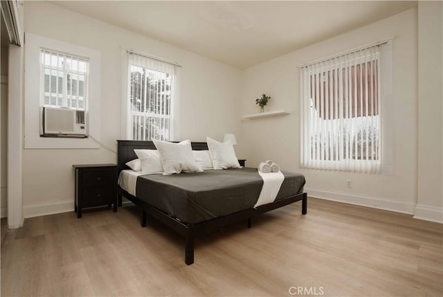 bedroom with light hardwood / wood-style floors and cooling unit