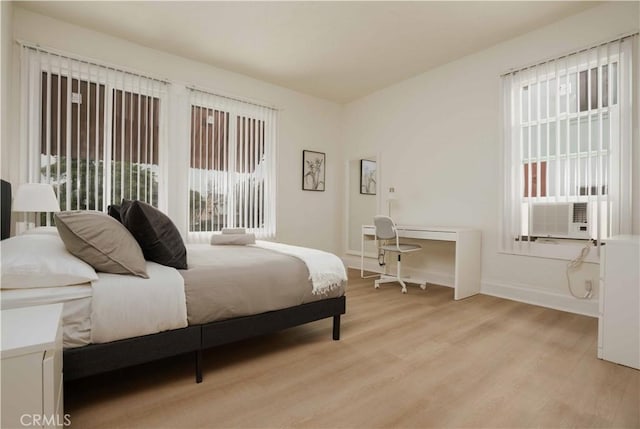 bedroom with light hardwood / wood-style floors and cooling unit