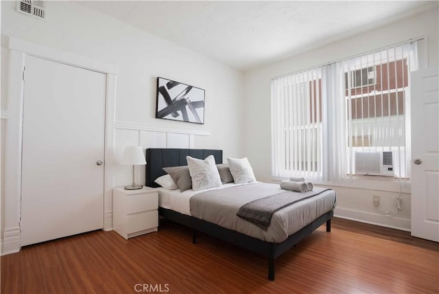 bedroom with hardwood / wood-style flooring and cooling unit