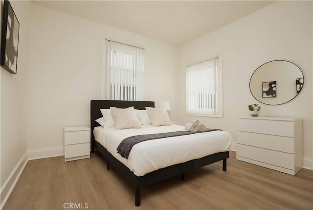 bedroom featuring hardwood / wood-style flooring and multiple windows