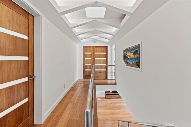 corridor featuring light hardwood / wood-style floors and lofted ceiling