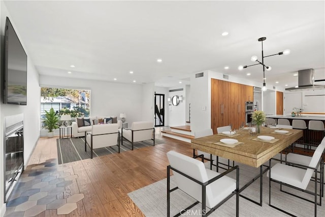 dining space featuring light hardwood / wood-style floors and a notable chandelier