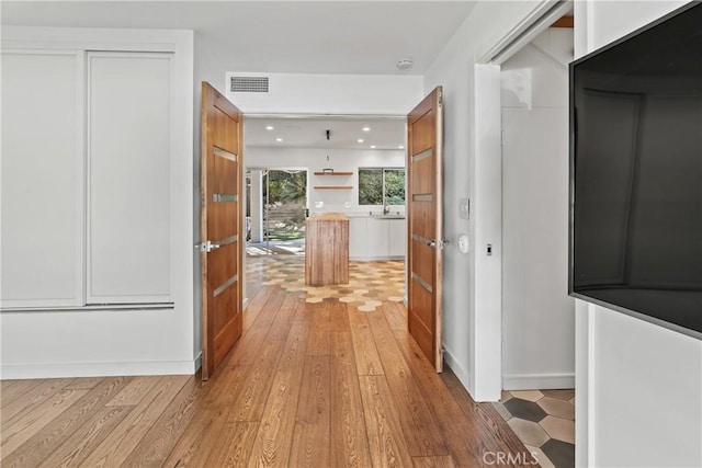 corridor with light hardwood / wood-style flooring