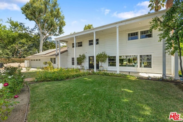 view of front of house with a garage and a front lawn