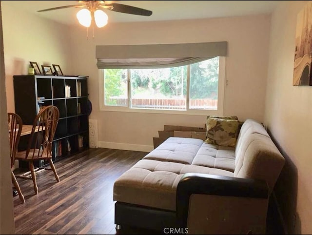 living room with ceiling fan and dark wood-type flooring