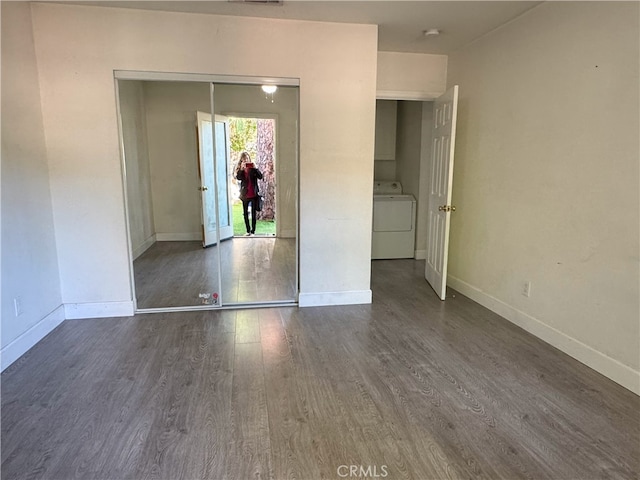 spare room featuring washer / clothes dryer and dark wood-type flooring