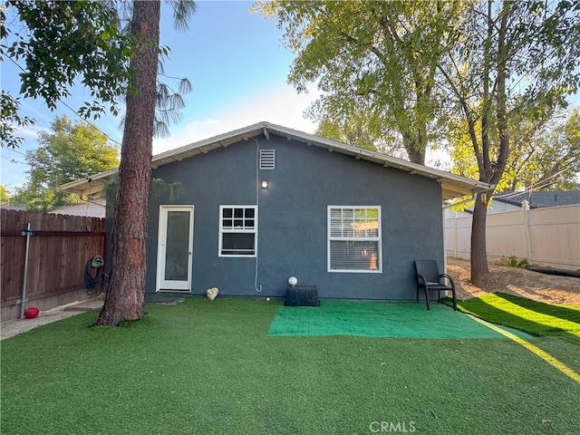 rear view of property with a yard