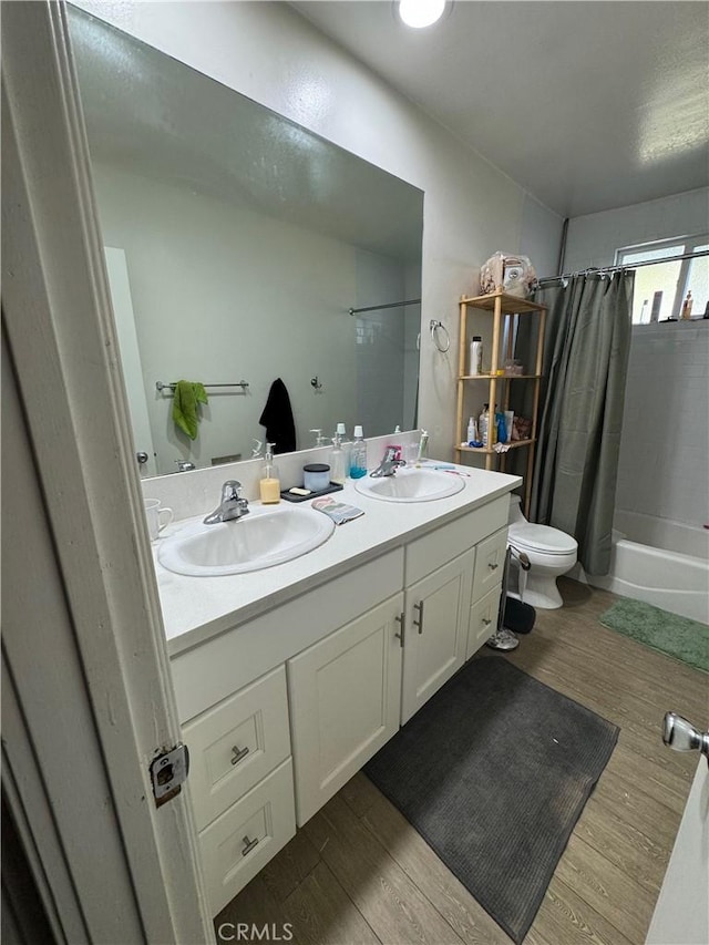 full bathroom featuring hardwood / wood-style flooring, vanity, toilet, and shower / bathtub combination with curtain