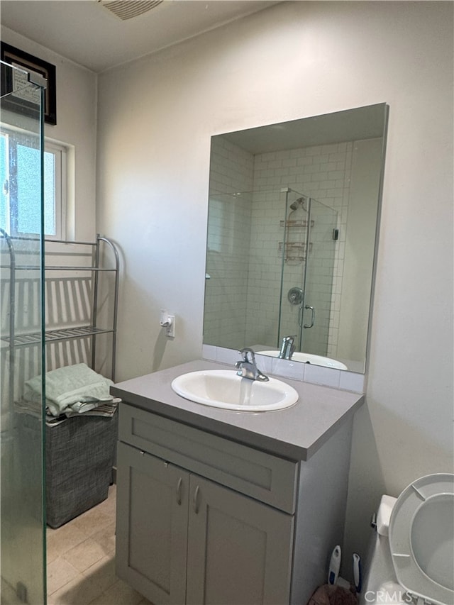 bathroom featuring tile patterned flooring, vanity, and a shower with shower door