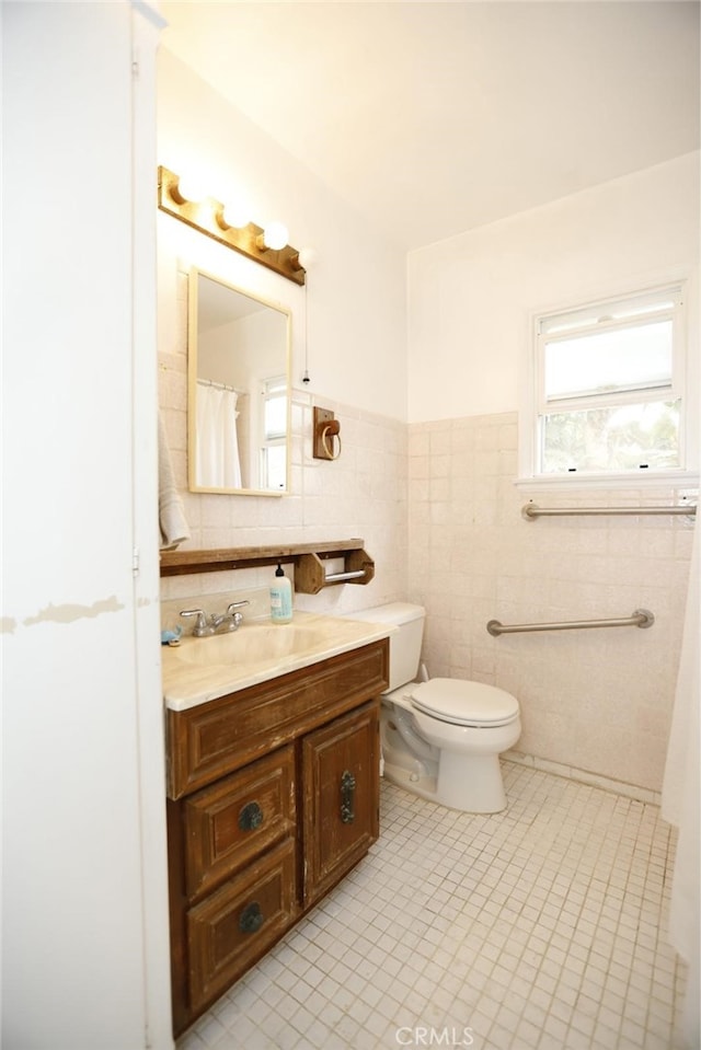 bathroom with tile walls, tile patterned floors, vanity, and toilet