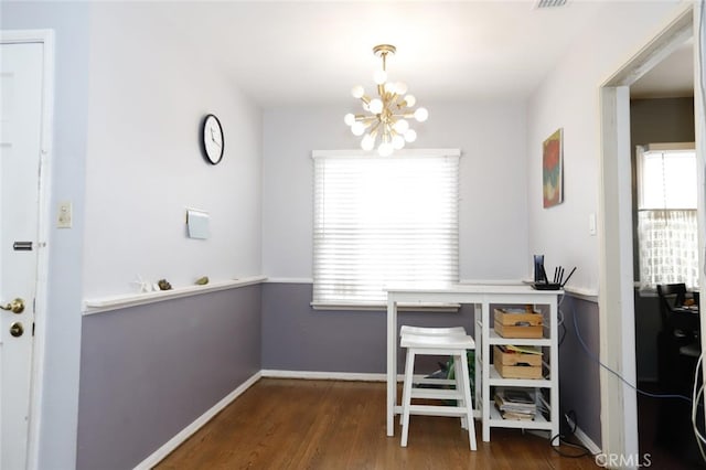 dining room with dark hardwood / wood-style flooring and a notable chandelier