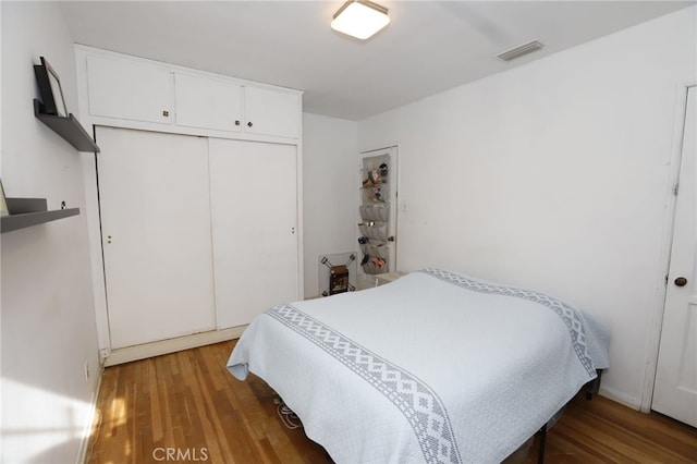 bedroom with a closet and dark hardwood / wood-style flooring