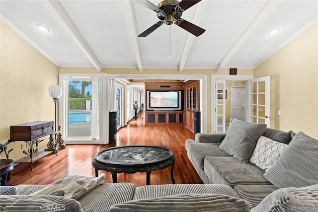 living room featuring lofted ceiling with beams, a ceiling fan, wood-type flooring, and ornamental molding