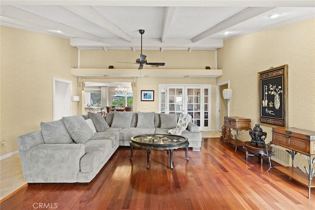 living area with beamed ceiling, a ceiling fan, hardwood / wood-style floors, french doors, and baseboards