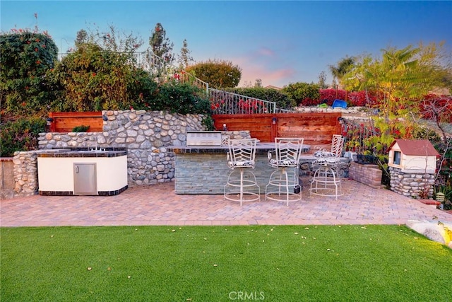 view of patio featuring exterior kitchen and outdoor dry bar