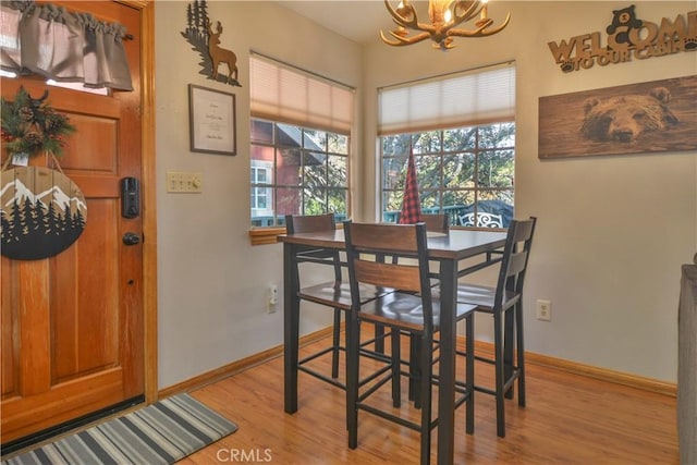 dining room with light hardwood / wood-style floors and an inviting chandelier