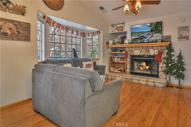 living room with hardwood / wood-style flooring, ceiling fan, a wealth of natural light, and vaulted ceiling