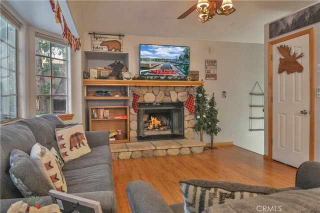 living room with hardwood / wood-style flooring, ceiling fan, and a fireplace