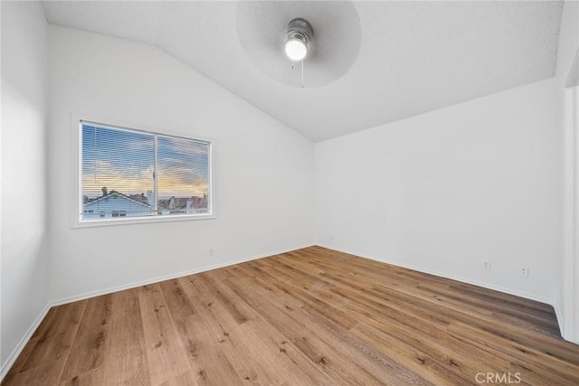 spare room featuring hardwood / wood-style floors, vaulted ceiling, and ceiling fan