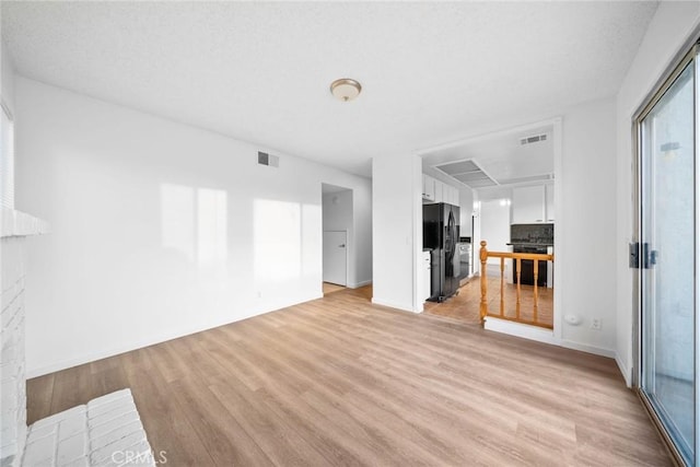 unfurnished living room with a fireplace and light wood-type flooring