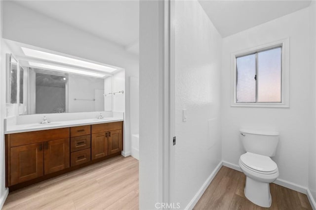 bathroom featuring wood-type flooring, vanity, and toilet