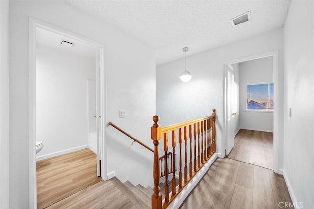 staircase featuring wood-type flooring and a textured ceiling