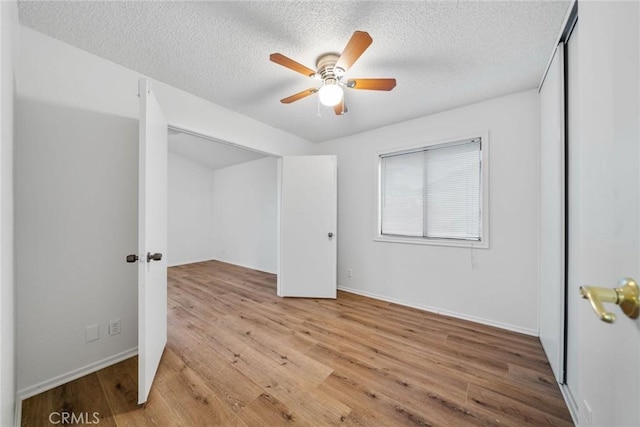 bedroom with a textured ceiling, light hardwood / wood-style flooring, and ceiling fan