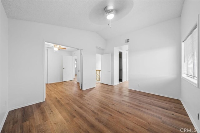 unfurnished bedroom featuring hardwood / wood-style floors, vaulted ceiling, and ceiling fan