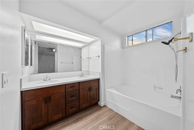 bathroom with washtub / shower combination, vanity, and hardwood / wood-style flooring