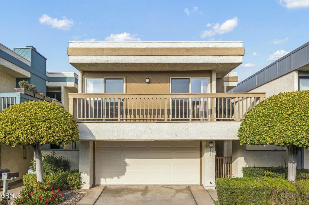 townhome / multi-family property featuring a balcony and a garage