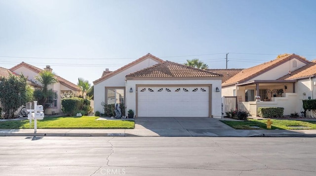 view of front facade with stucco siding, driveway, a front yard, a garage, and a tiled roof