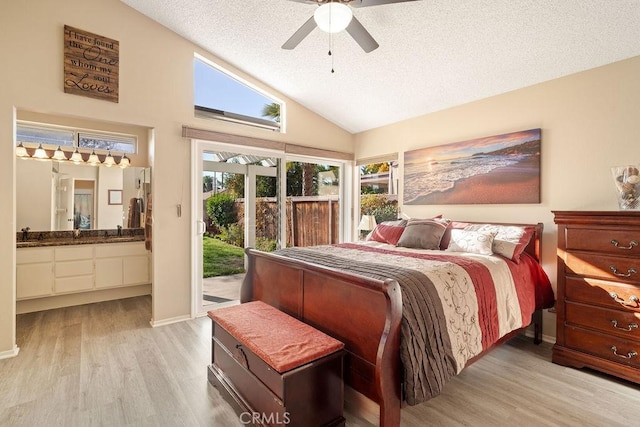 bedroom with light wood-type flooring, ensuite bathroom, a textured ceiling, access to exterior, and vaulted ceiling