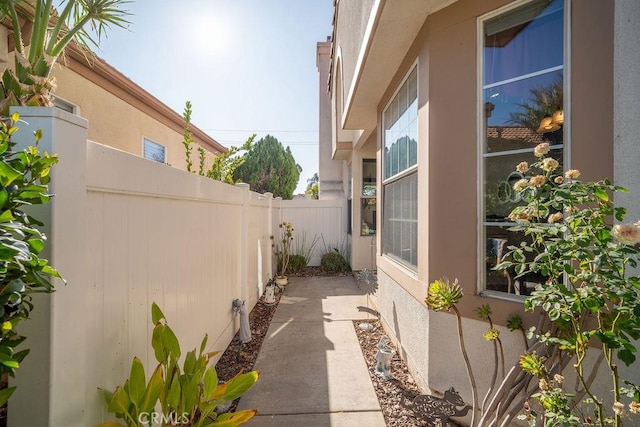 view of side of property with stucco siding and a fenced backyard