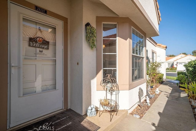 view of exterior entry with stucco siding