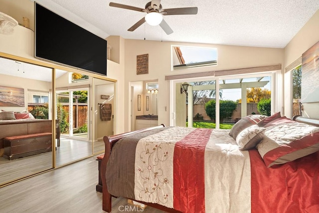 bedroom featuring access to outside, a textured ceiling, wood finished floors, ceiling fan, and vaulted ceiling