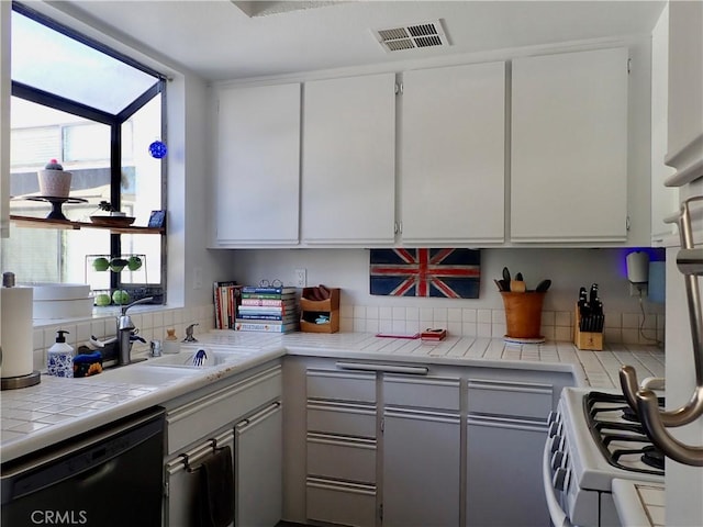 kitchen featuring white cabinetry, dishwasher, tile counters, decorative backsplash, and range