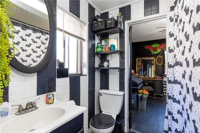 bathroom featuring a shower with curtain, vanity, toilet, and tile walls