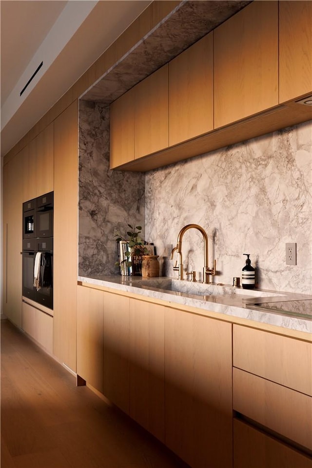 kitchen featuring light hardwood / wood-style floors, sink, double oven, and decorative backsplash