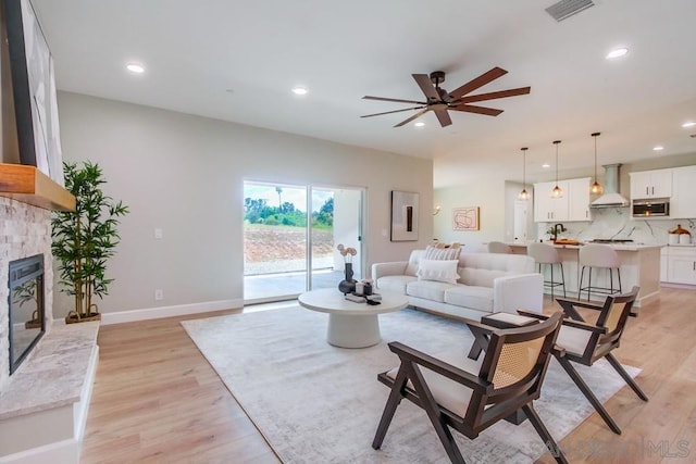 living room with light wood-type flooring and ceiling fan