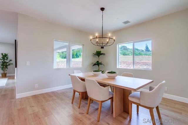 dining room featuring a wealth of natural light, light hardwood / wood-style flooring, and a chandelier