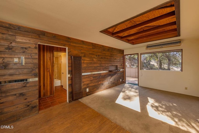 spare room featuring beam ceiling, wood walls, and dark wood-type flooring