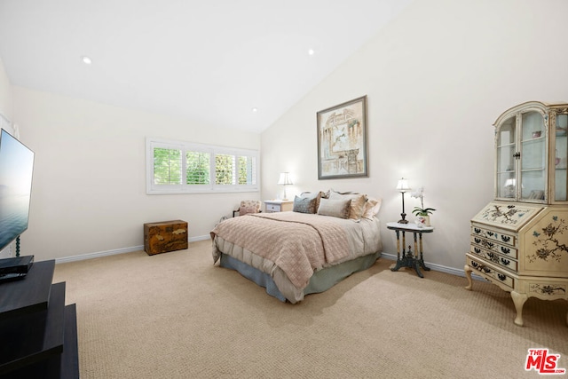 bedroom featuring light colored carpet and high vaulted ceiling