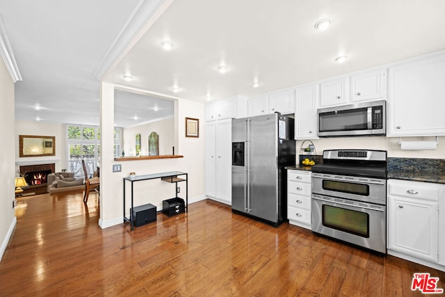 kitchen with white cabinets, stainless steel appliances, dark hardwood / wood-style floors, and crown molding